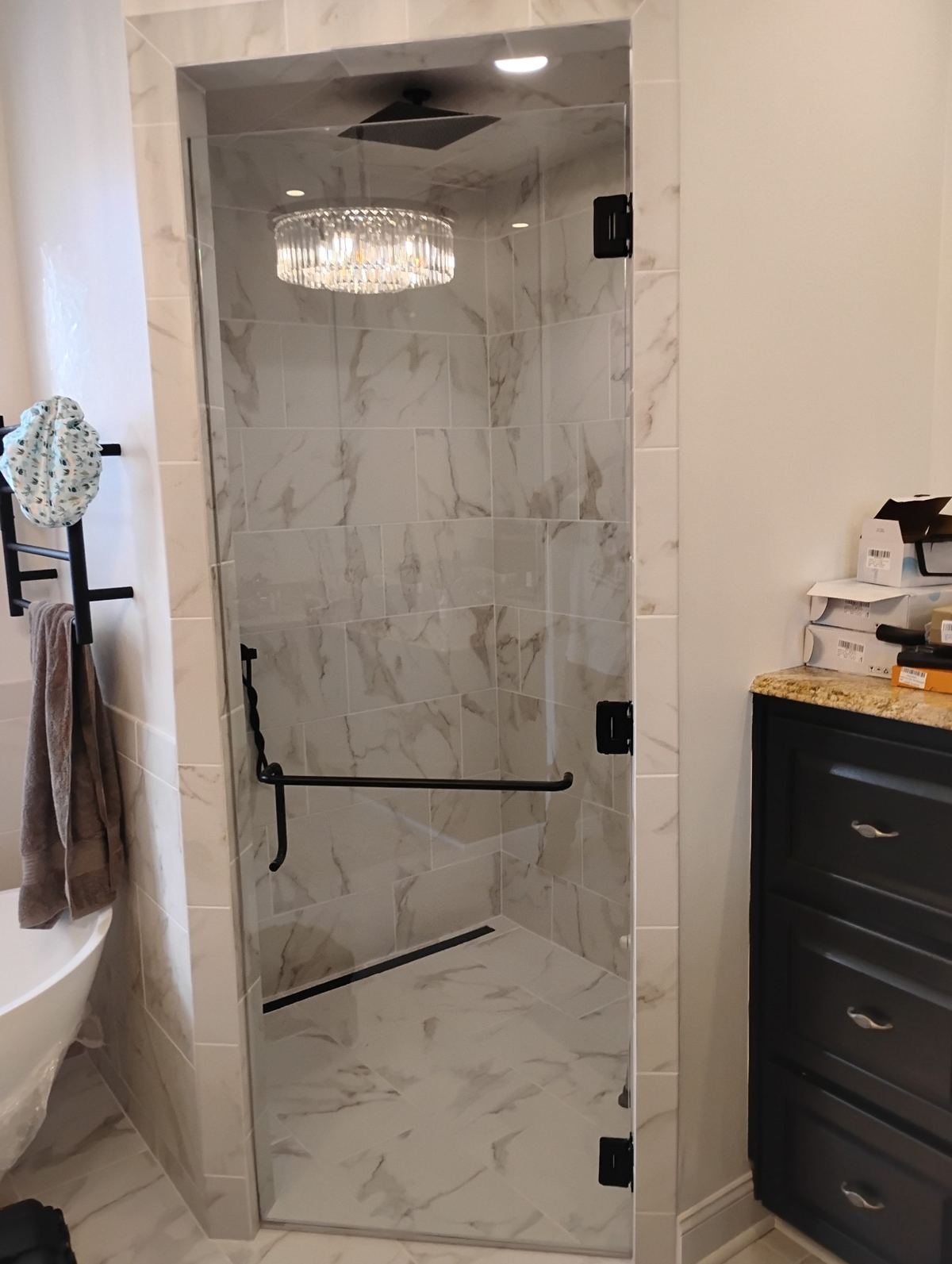 Frameless shower enclosure with matte black hardware installed in Southwest Georgia bathroom